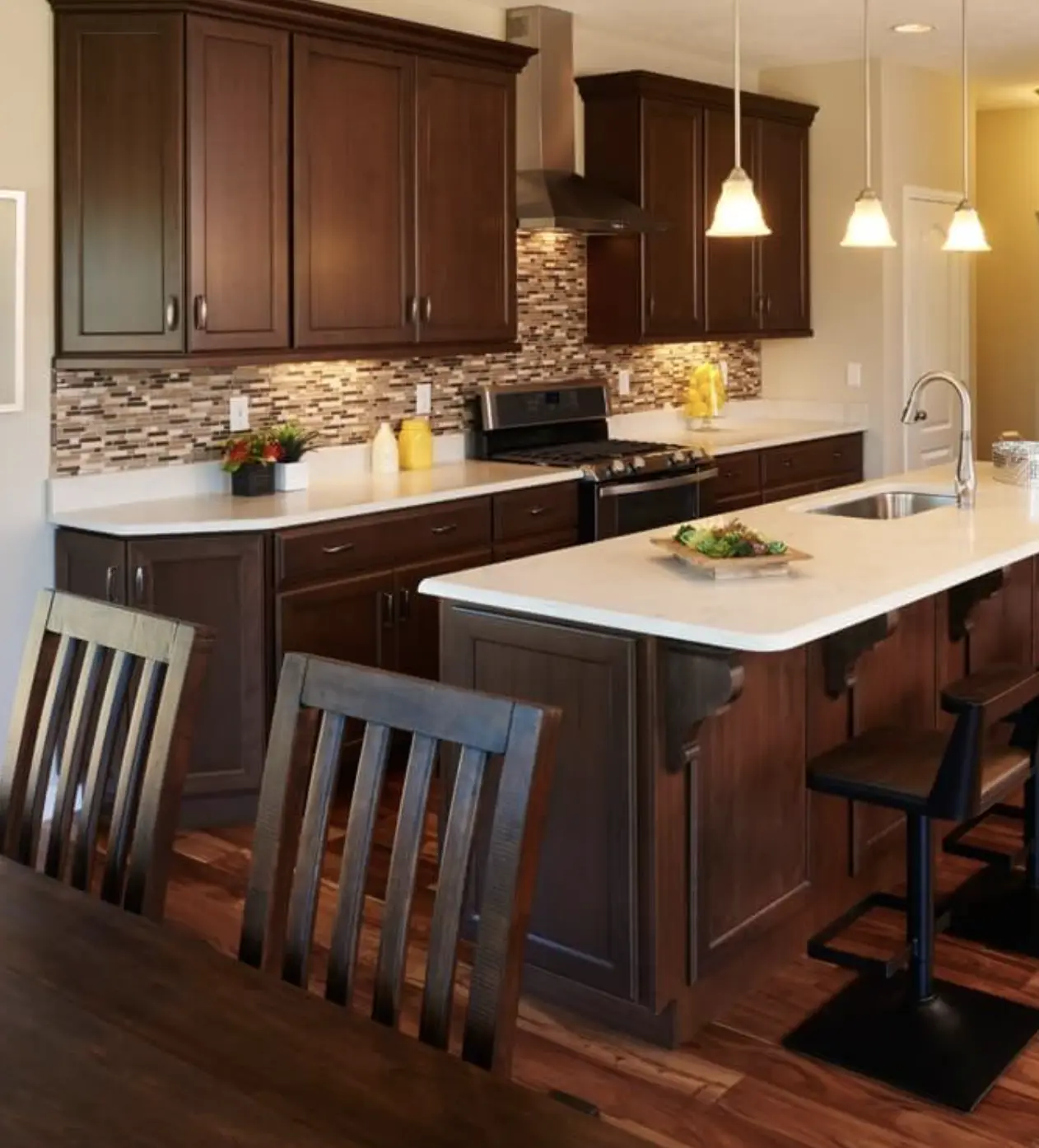 Model Kitchen with pendant lights, white countertops, and dark wood cabinets
