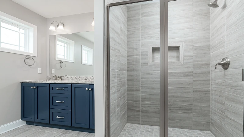 Stage 5 - Final Finishes.jpg: Finished bathroom featuring tiled walk-in shower, glass enclosure, and double vanity with modern lighting.